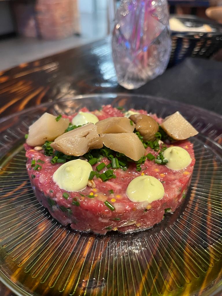 tatar wołowy z majonezem słonecznikiem marynowanym borowikiem na talerzu w restauracji IDA kuchnia i wino